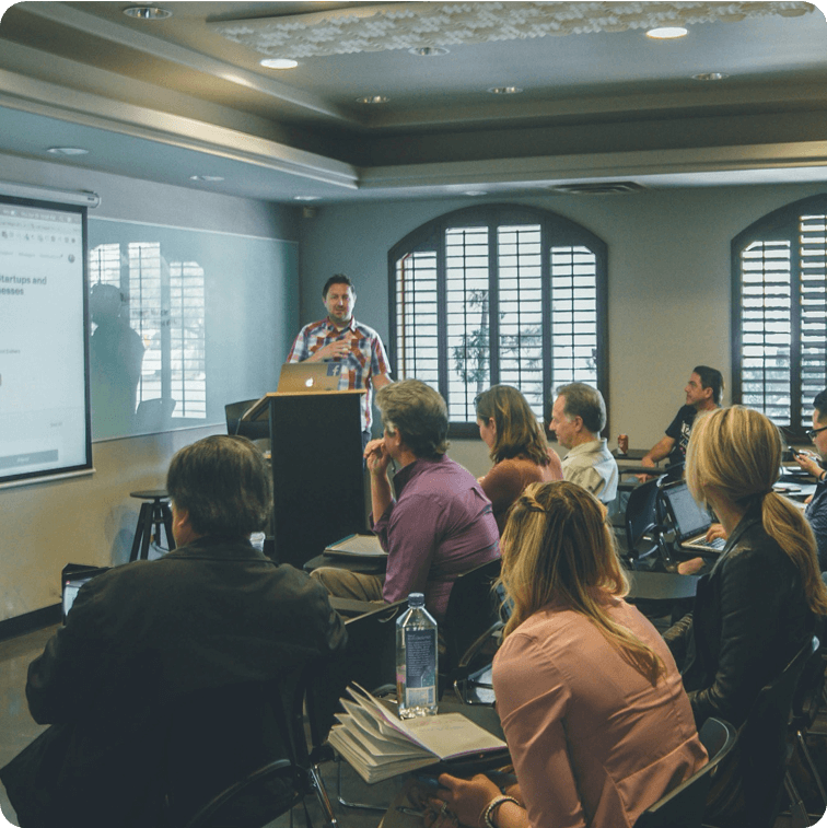 Group of professionals in a classroom setting engaged in Spotfire training, actively participating in data visualization training and interactive dashboard training, with a presenter leading a hands-on Spotfire course and Spotfire bootcamp