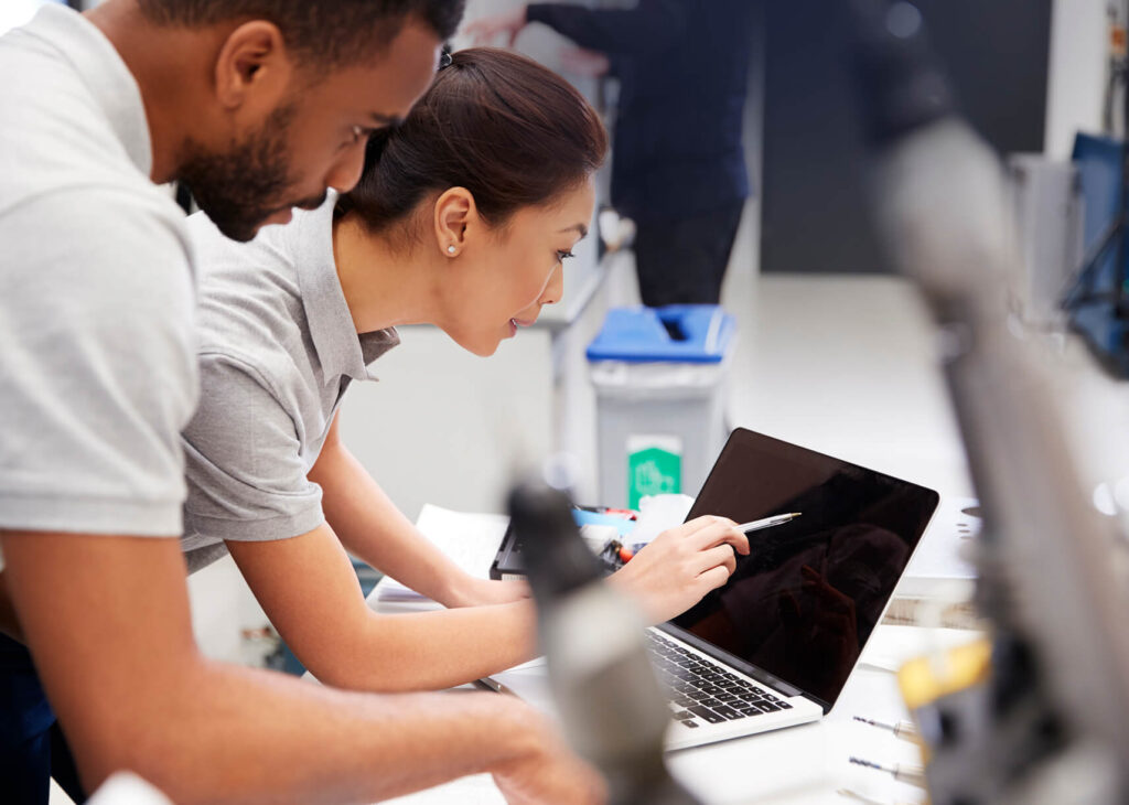 Two professionals collaborating over a laptop during Spotfire training, actively engaging in data visualization training and interactive dashboard training as part of a hands-on Spotfire course and Spotfire bootcamp.